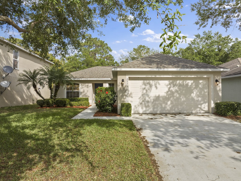 2575 12th Square Southwest Vero Beach, FL 32968 - Photo 24 of 31 a view of a house with a small yard and a large tree