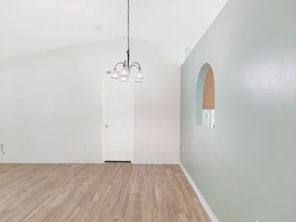 a view of a room with wooden floor and chandelier
