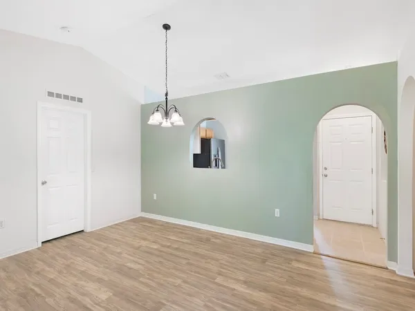 a view of a room with wooden floor and ceiling fan
