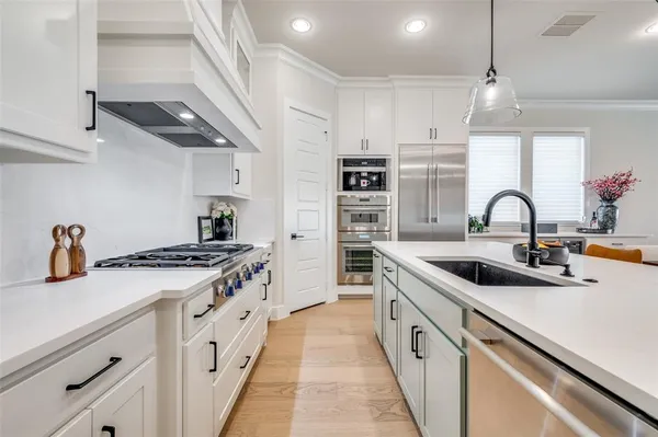 a kitchen with stainless steel appliances granite countertop a sink stove and cabinets