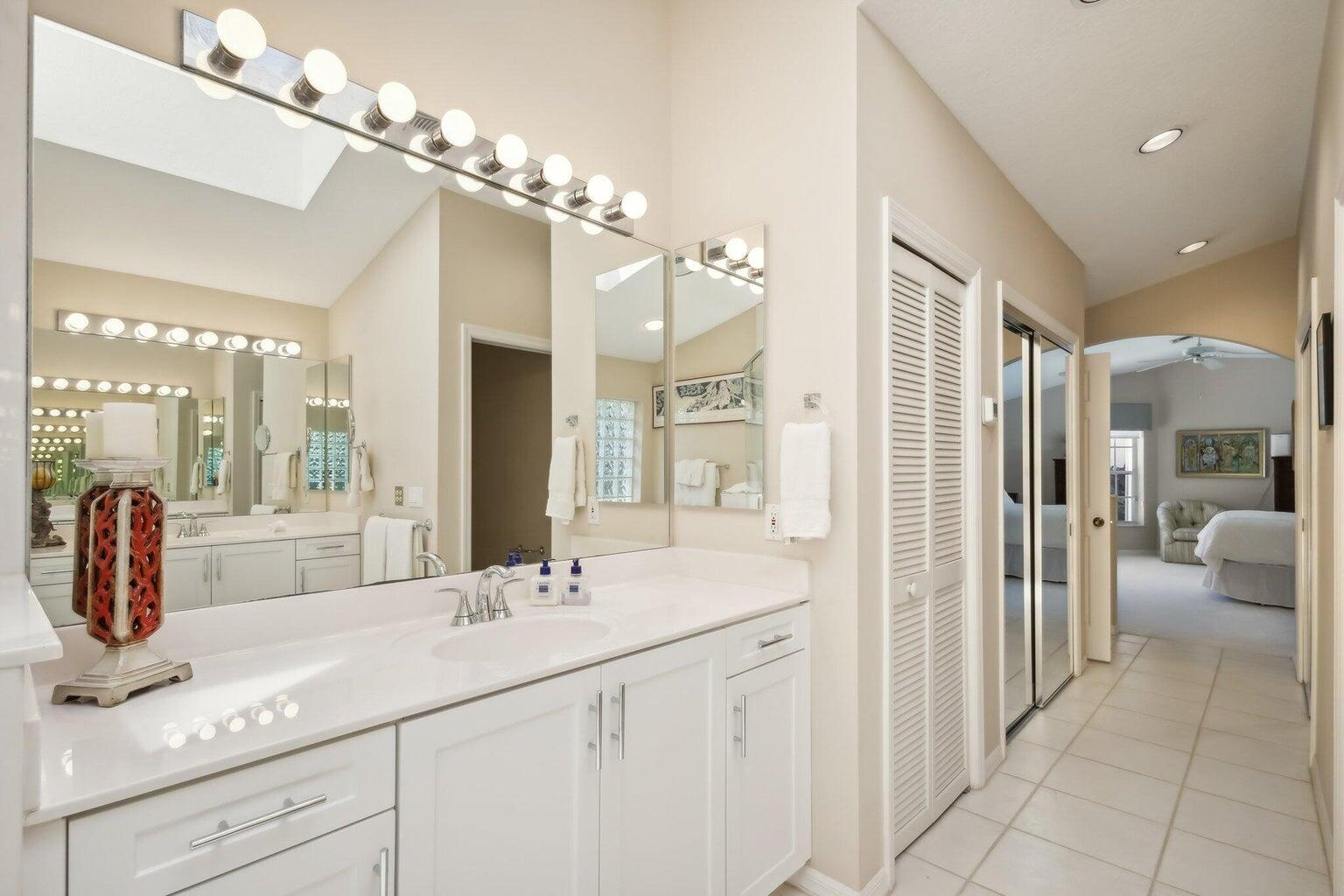 16481 Riverwind Drive Jupiter, FL 33477 - Photo 27 of 49 a bathroom with a double vanity sink and a mirror
