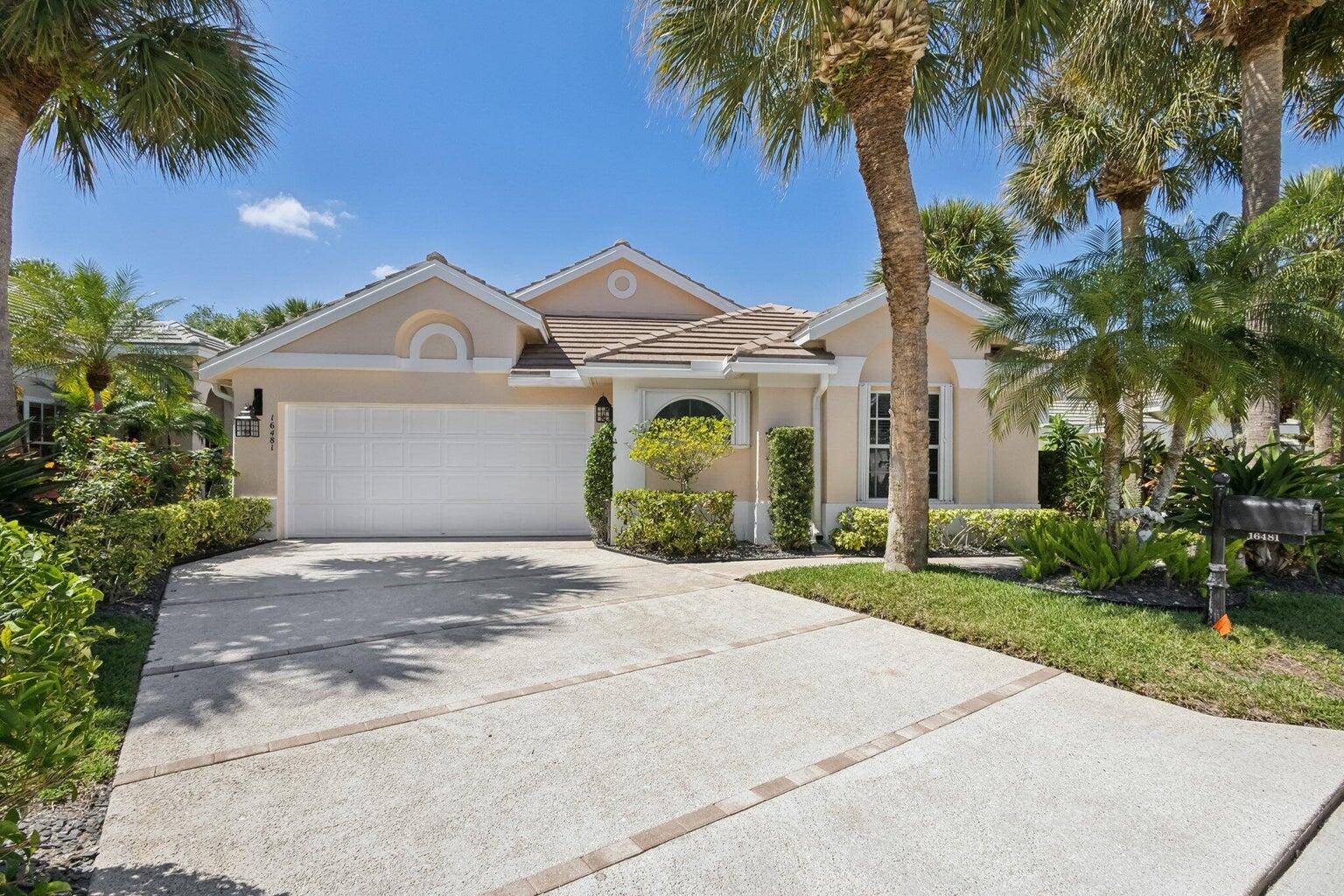 16481 Riverwind Drive Jupiter, FL 33477 - Photo 44 of 49 a front view of a house with a garden