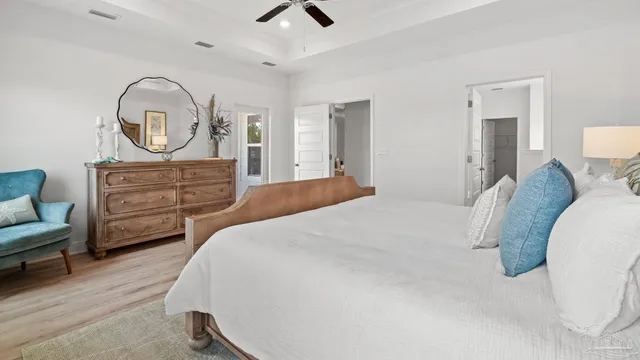 a bedroom with a bed a dresser and with mirror