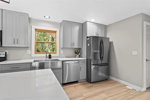 a kitchen with granite countertop a refrigerator and a sink