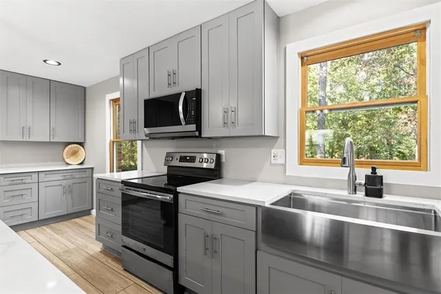a kitchen with granite countertop a sink a counter top space appliances and cabinets