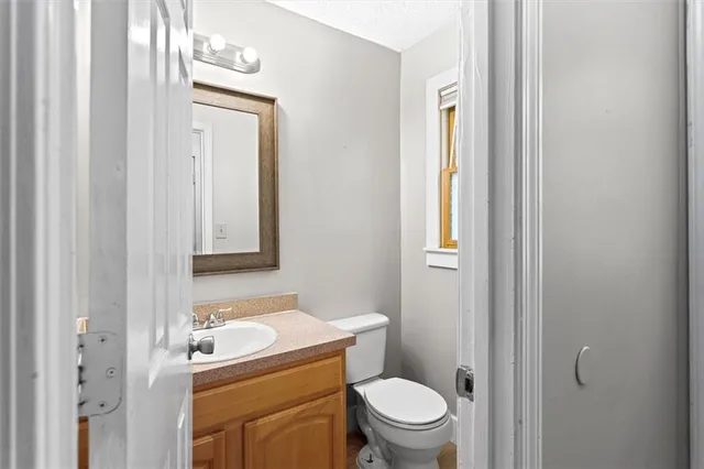 a bathroom with a toilet sink vanity and mirror