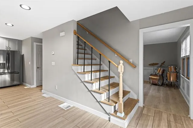 a view of a livingroom with wooden floor and stairs