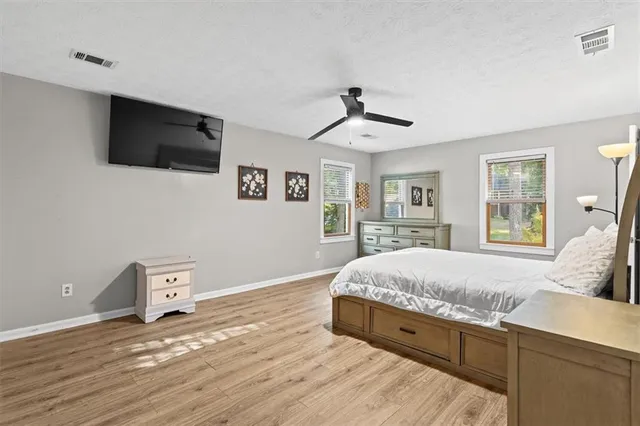 a spacious bedroom with a bed and a flat screen tv