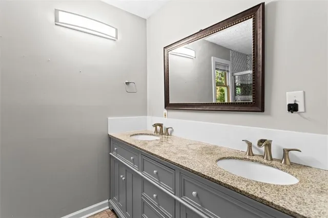 a bathroom with a granite countertop sink and a mirror