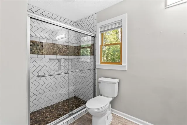 a bathroom with a toilet and a shower