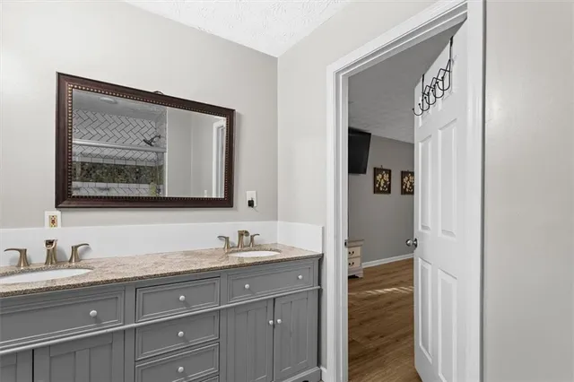 a bathroom with a granite countertop sink mirror and vanity
