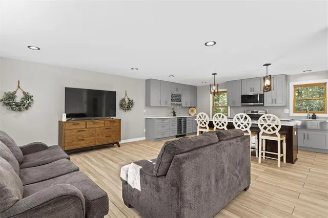 a living room with furniture kitchen view and a flat screen tv