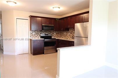 1861 Northwest 59th Way, Unit 2 Sunrise, FL 33313 - Photo 11 of 11 a kitchen with stainless steel appliances a refrigerator a stove a microwave a sink and a refrigerator