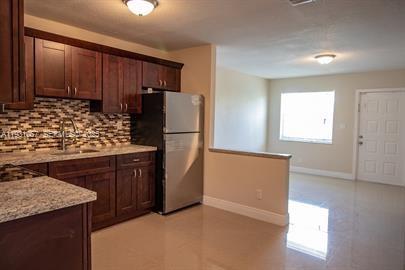 1861 Northwest 59th Way, Unit 2 Sunrise, FL 33313 - Photo 2 of 11 a kitchen with stainless steel appliances granite countertop a refrigerator and a stove
