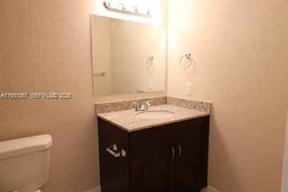 1861 Northwest 59th Way, Unit 2 Sunrise, FL 33313 - Photo 7 of 11 a bathroom with a granite countertop sink and a toilet