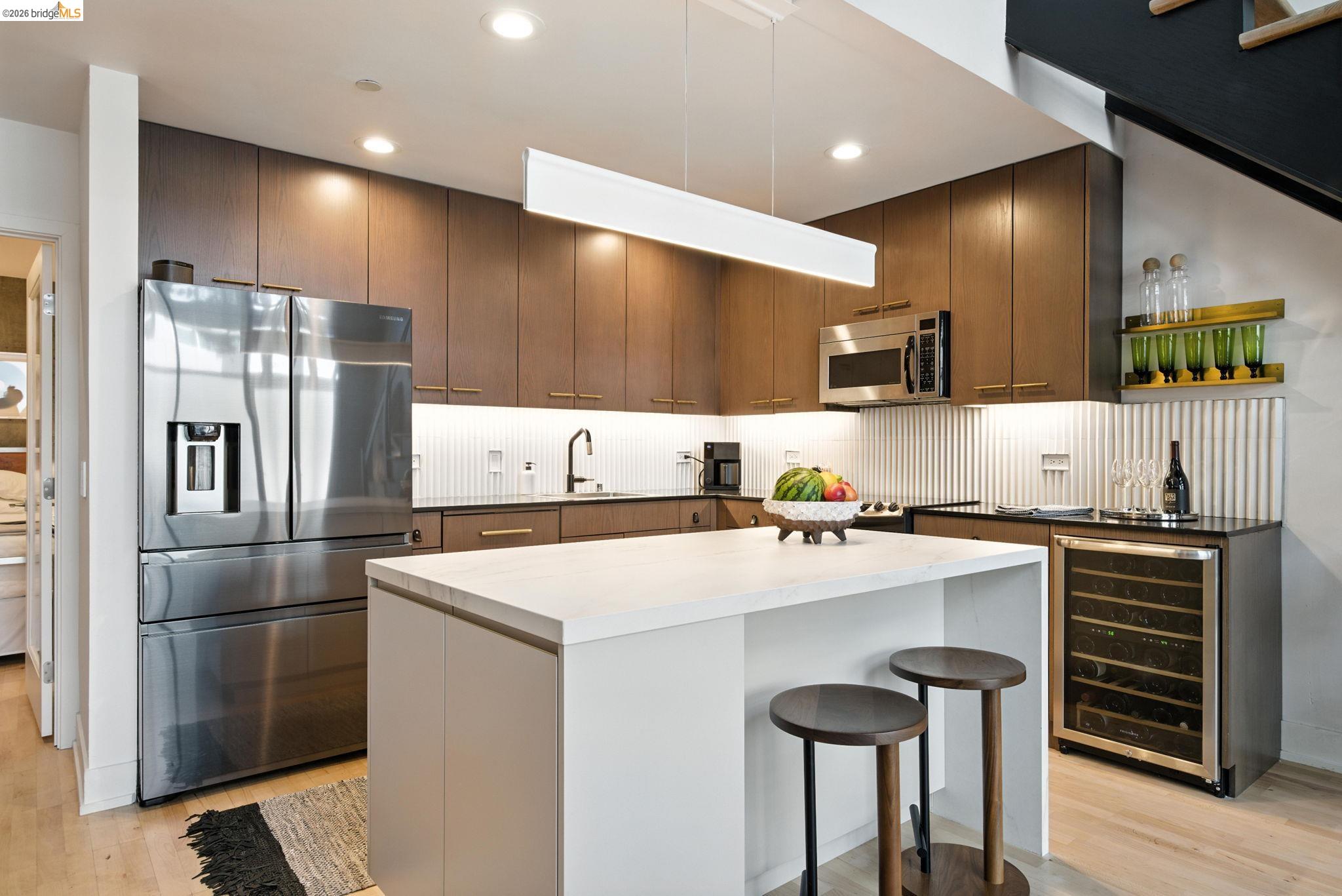 311 Oak Street, Unit 102 Oakland, CA 94607 - Photo 12 of 52 a kitchen with kitchen island a stove a refrigerator and a sink