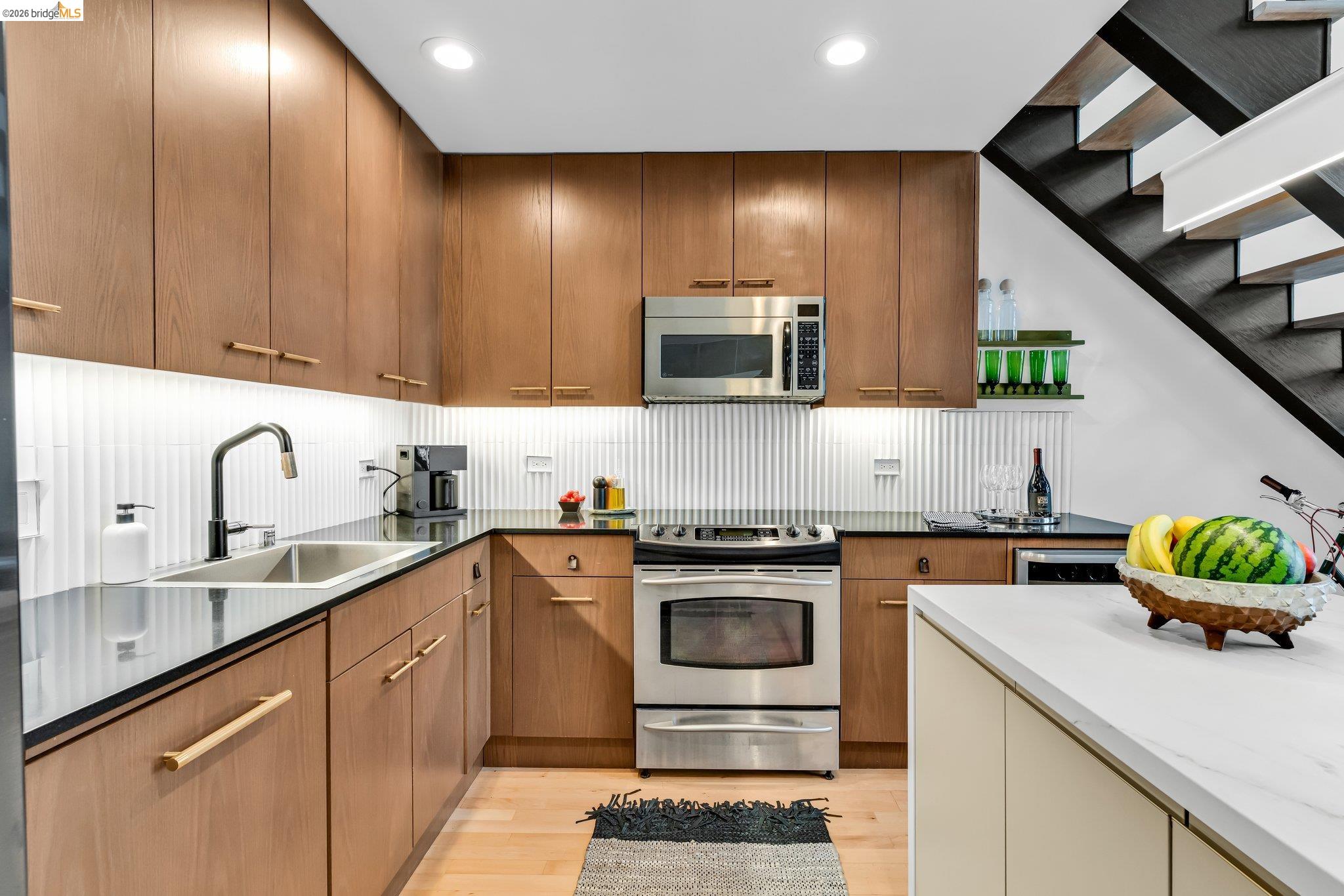 311 Oak Street, Unit 102 Oakland, CA 94607 - Photo 13 of 52 a kitchen with kitchen island granite countertop stainless steel appliances lots of counter top space cabinets and a sink