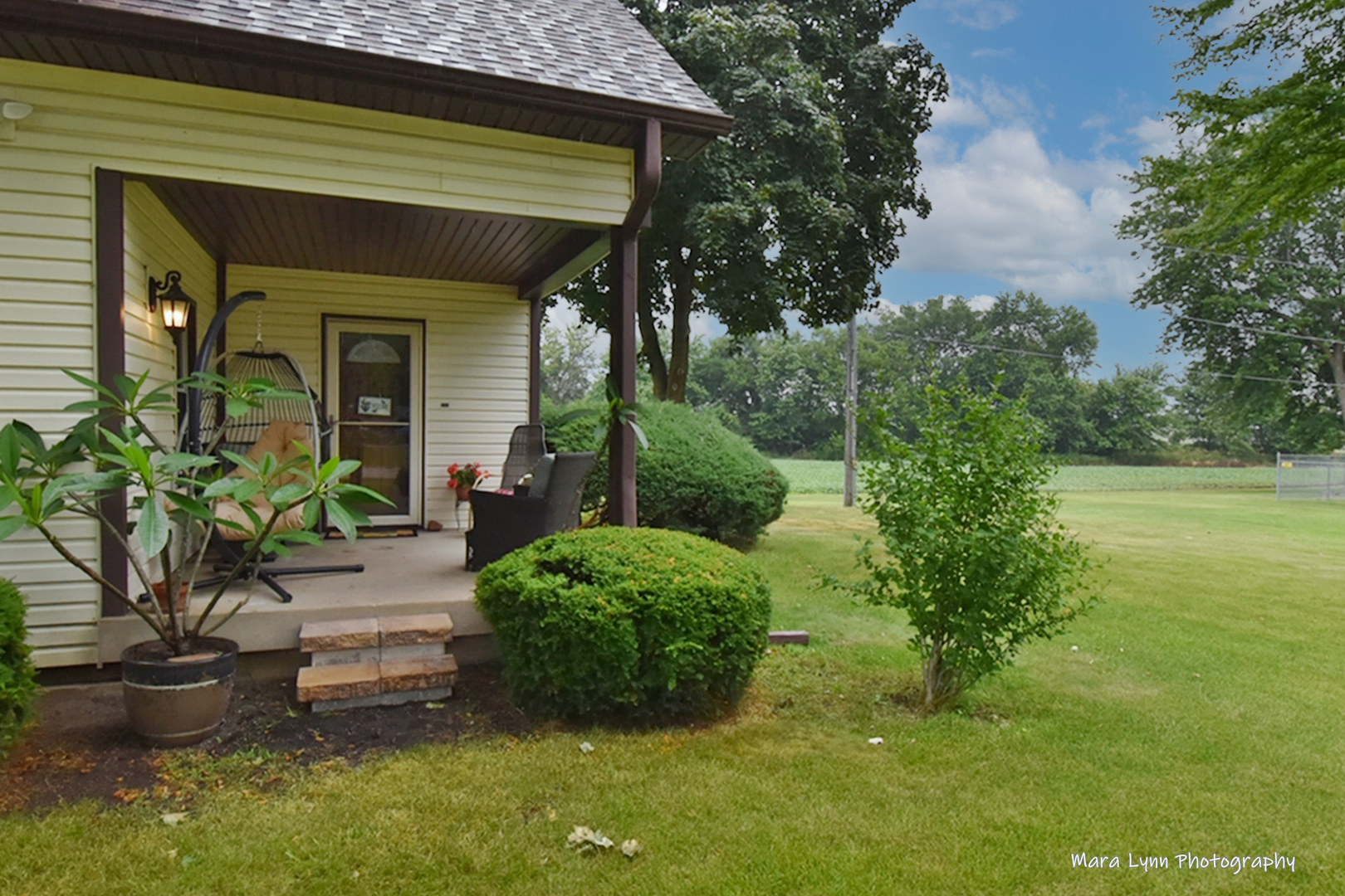 1250 Mettel Road Aurora, IL 60505 - Photo 3 of 49 a view of a small house with potted plants and a bench