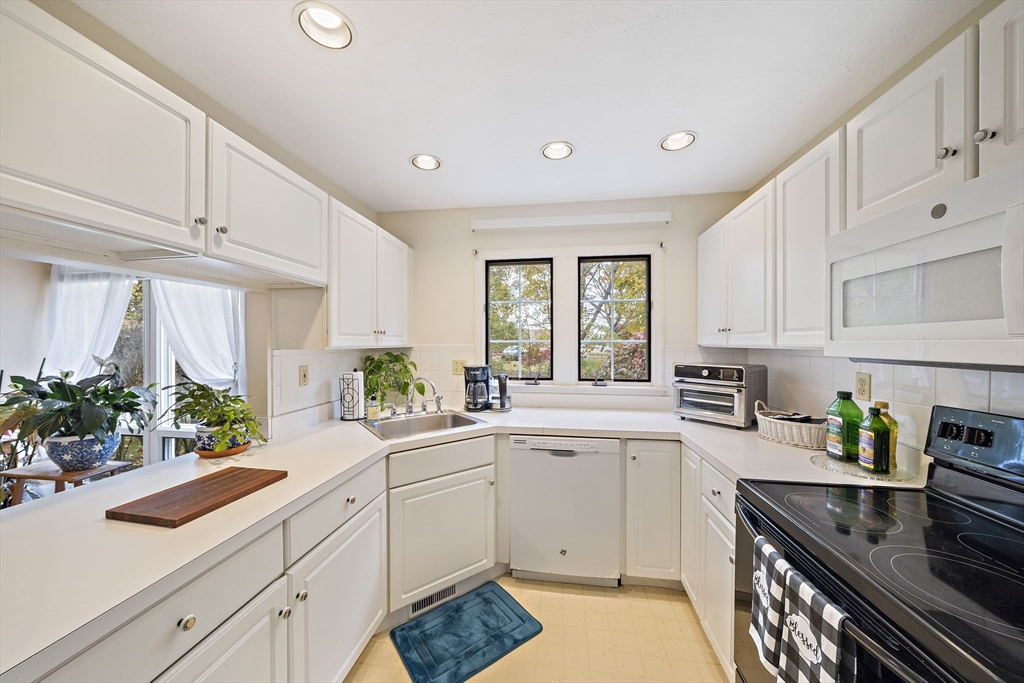 501 Auburn Street, Unit 404 Whitman, MA 02382 - Photo 6 of 35 a kitchen with a sink white cabinets and white appliances