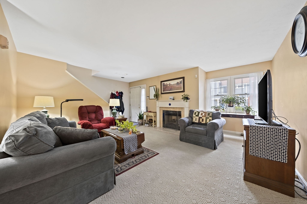 501 Auburn Street, Unit 404 Whitman, MA 02382 - Photo 8 of 35 a living room with furniture a fireplace and a flat screen tv