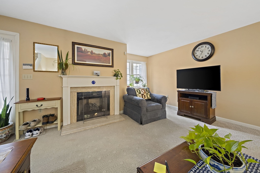 501 Auburn Street, Unit 404 Whitman, MA 02382 - Photo 10 of 35 a living room with furniture a flat screen tv and a fireplace