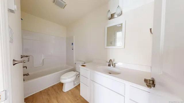 a white toilet sitting next to a bath tub