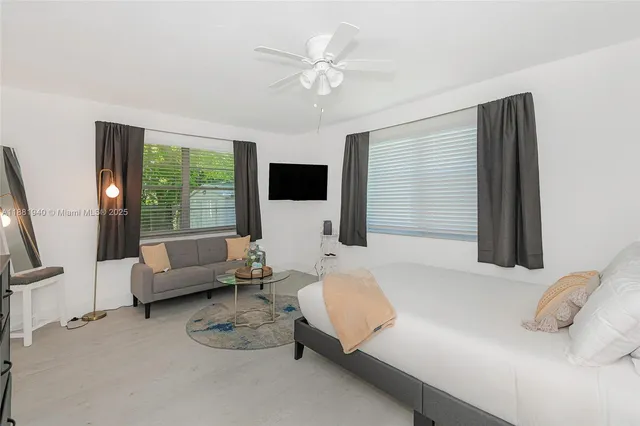 a bedroom with furniture and a large window