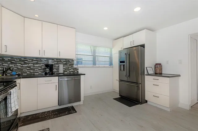 a kitchen with stainless steel appliances granite countertop a refrigerator and a stove top oven