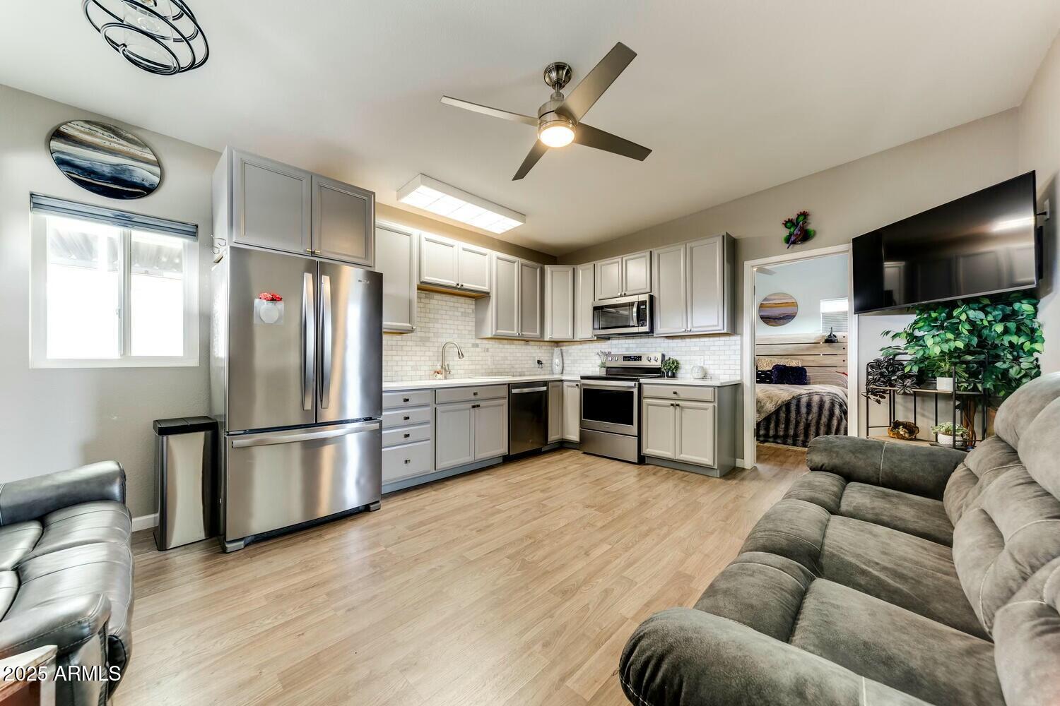 17200 West Bell Road, Unit 903 Surprise, AZ 85374 - Photo 11 of 21 a kitchen with stainless steel appliances granite countertop a refrigerator a stove a sink and a dining table with wooden floor