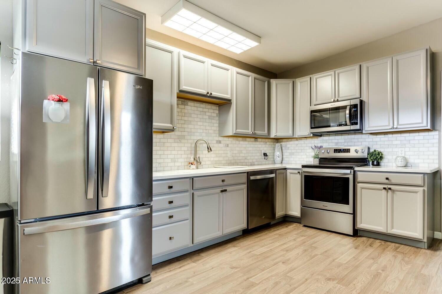17200 West Bell Road, Unit 903 Surprise, AZ 85374 - Photo 9 of 21 a kitchen with stainless steel appliances a refrigerator sink and microwave