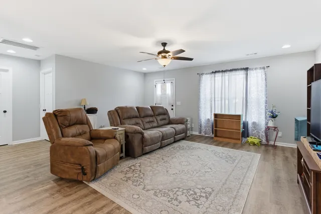 a living room with furniture a ceiling fan and a rug