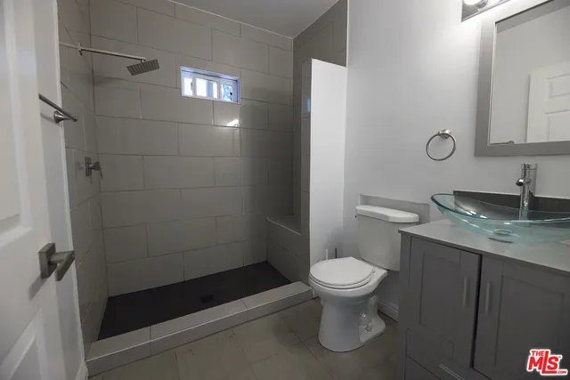 a bathroom with a granite countertop toilet a sink and a shower