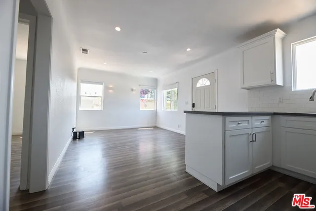 a kitchen with granite countertop white cabinets and white appliances