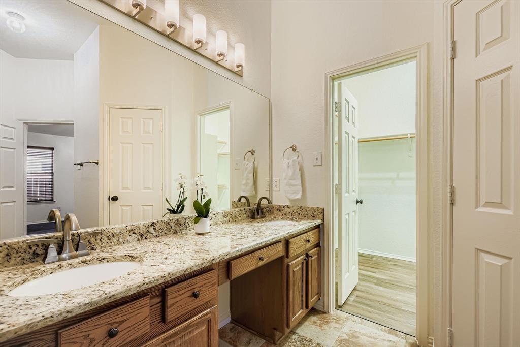 12407 Hawk Creek Drive Frisco, TX 75033 - Photo 20 of 33 a bathroom with a granite countertop sink and a mirror