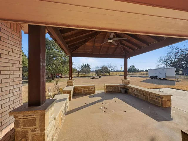 a view of a terrace with a table and chairs under an umbrella