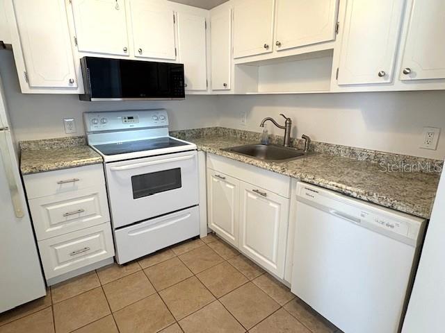 1901 Andover Way, Unit 38 Sun City Center, FL 33573 - Photo 11 of 33 a kitchen with granite countertop white cabinets and white appliances