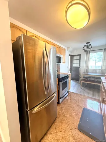 a kitchen with stainless steel appliances granite countertop a refrigerator a stove and a sink with granite countertops