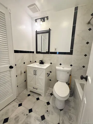 a bathroom with a sink toilet and mirror