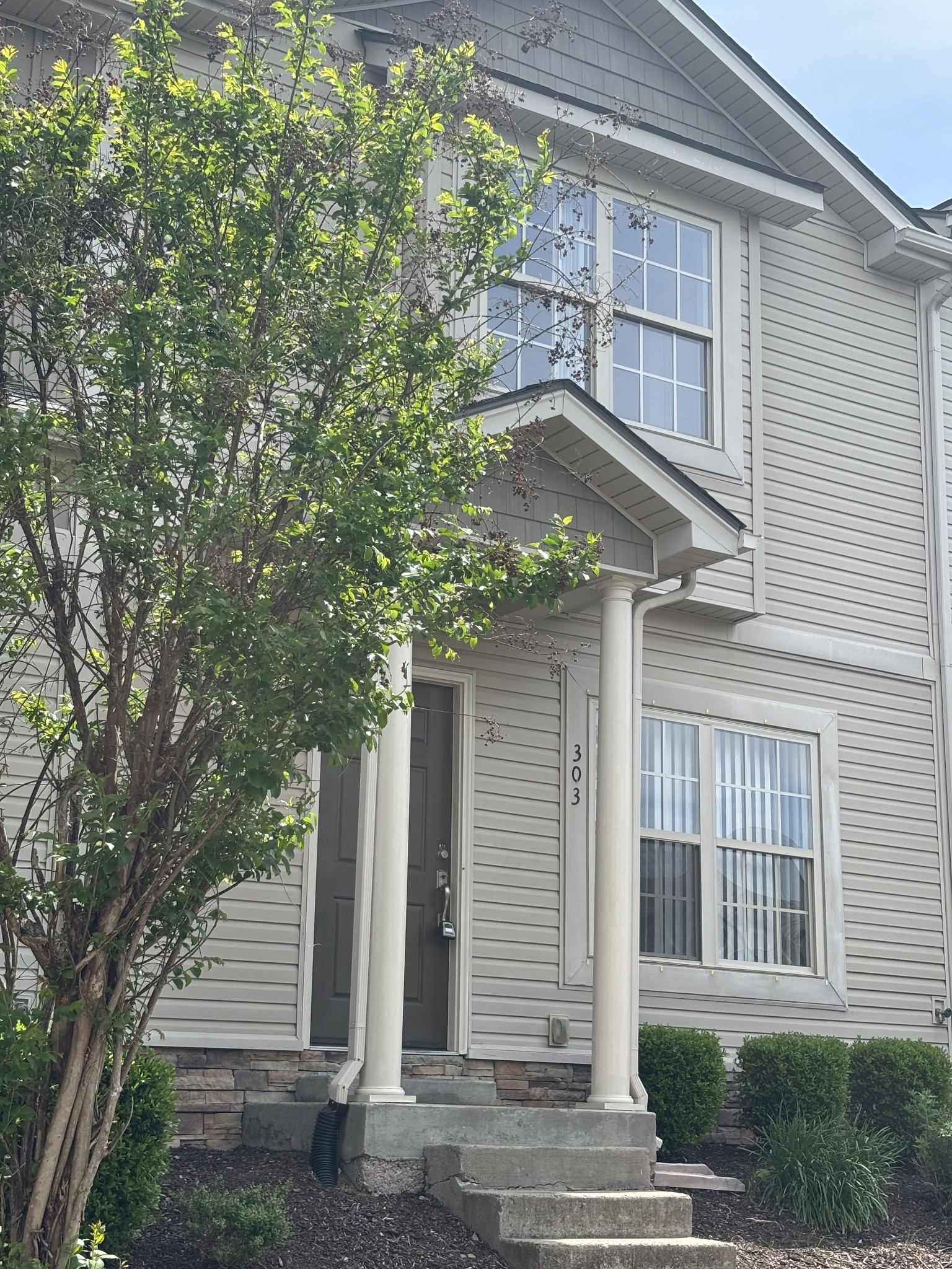735 Tulip Grove Road, Unit 303 Hermitage, TN 37076 - Photo 1 of 16 a yellow house with trees in front of it