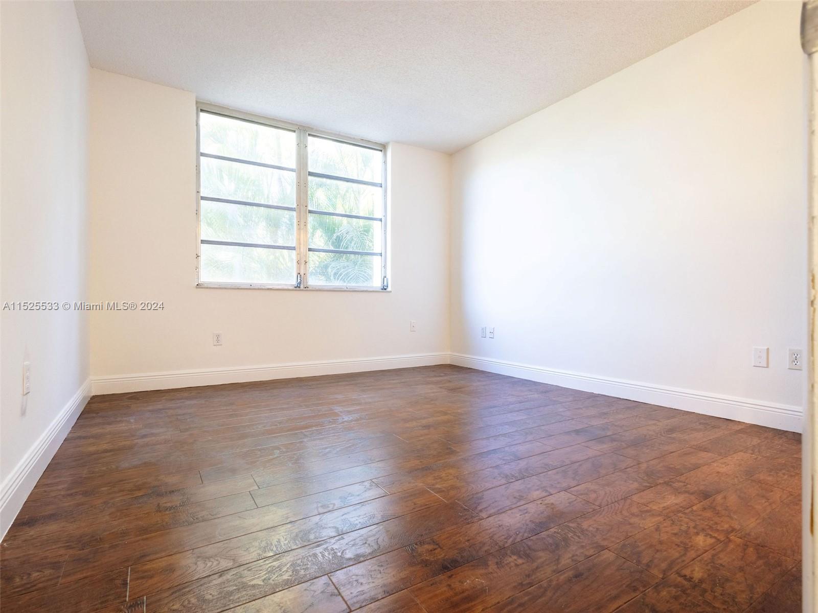 3285 Foxcroft Road, Unit E206 Miramar, FL 33025 - Photo 12 of 35 an empty room with wooden floor and windows