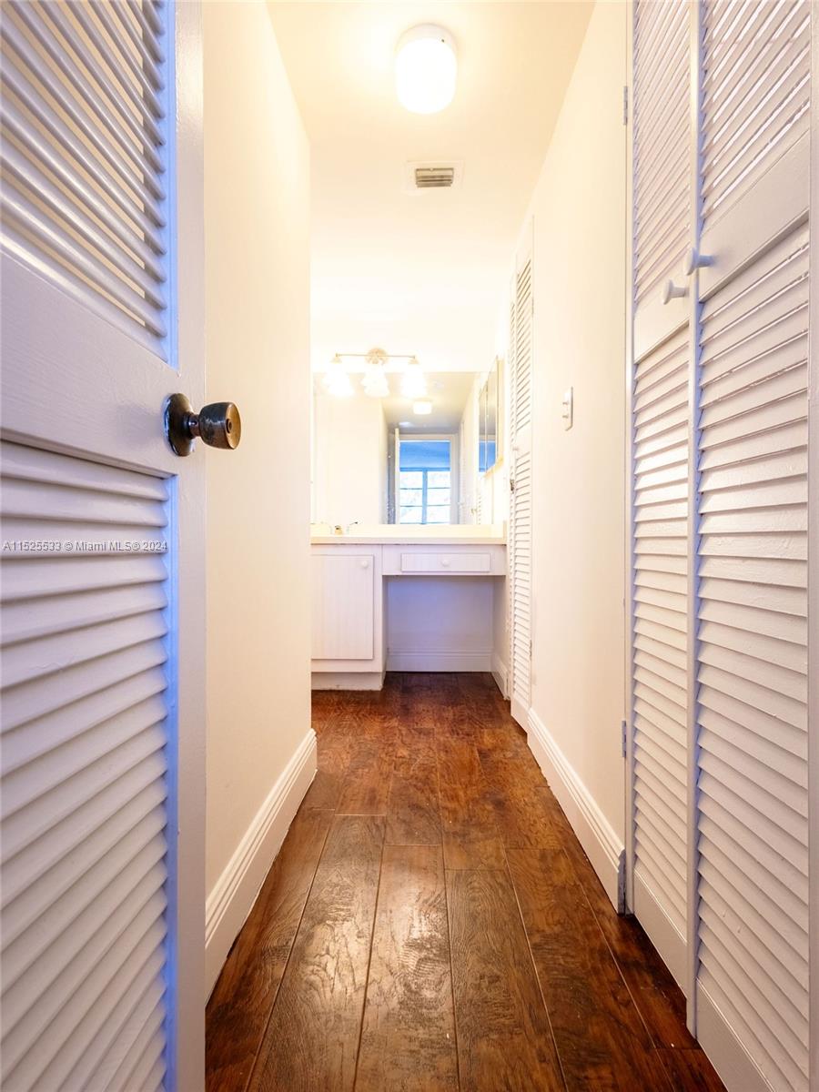 3285 Foxcroft Road, Unit E206 Miramar, FL 33025 - Photo 19 of 35 a view of a hallway with wooden floor and a bathroom