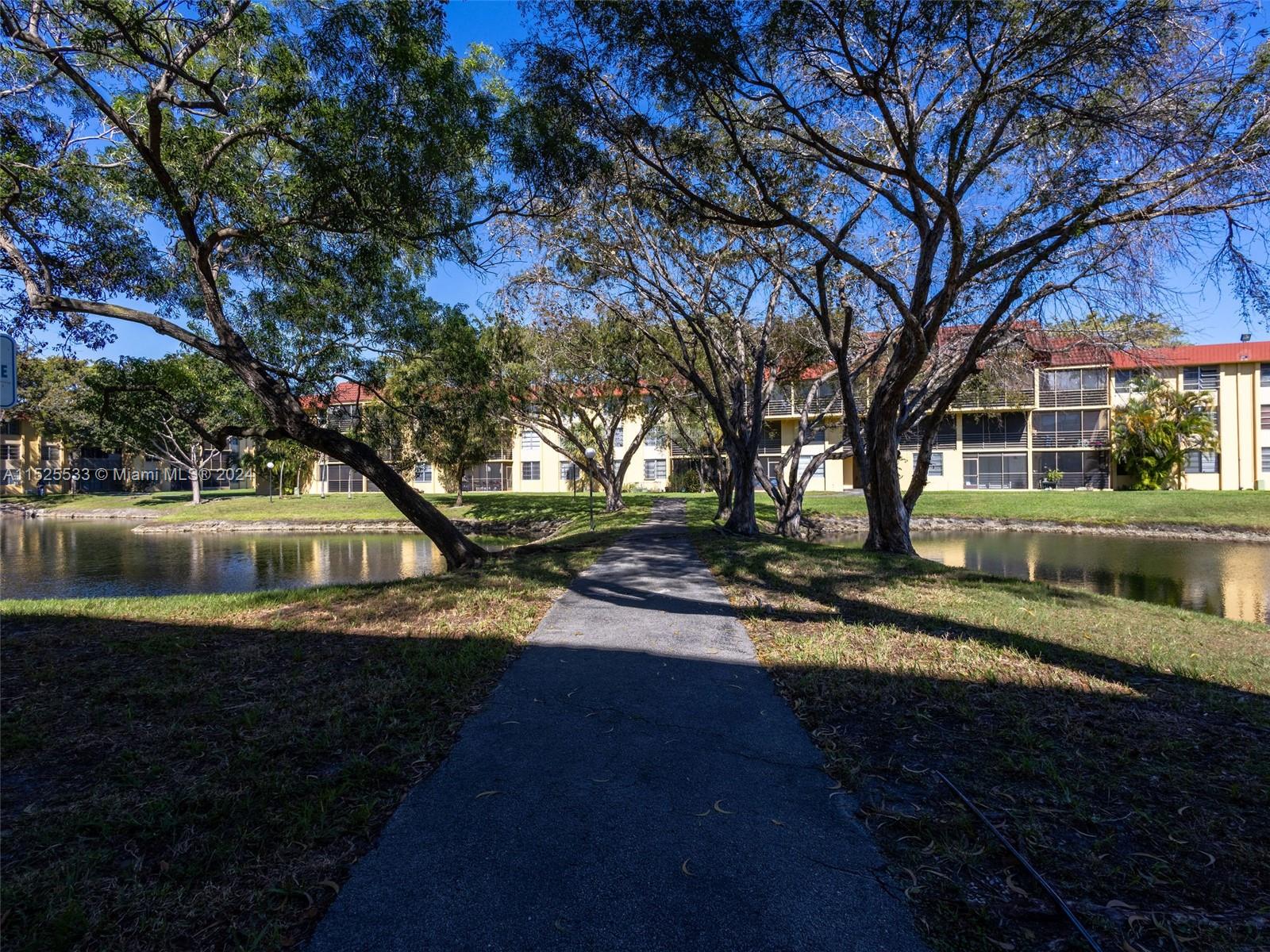 3285 Foxcroft Road, Unit E206 Miramar, FL 33025 - Photo 22 of 35 a view of a yard with plants and a lake view