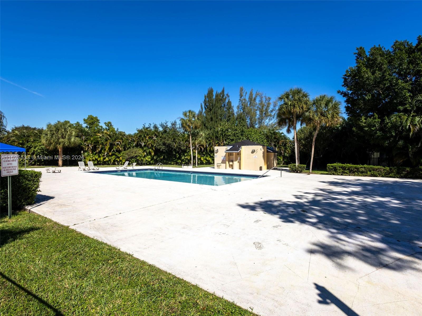 3285 Foxcroft Road, Unit E206 Miramar, FL 33025 - Photo 27 of 35 a view of yard with swimming pool and trees in the background