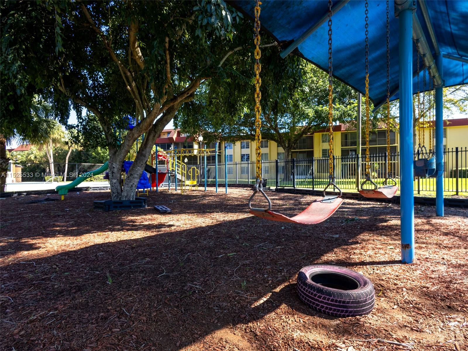 3285 Foxcroft Road, Unit E206 Miramar, FL 33025 - Photo 30 of 35 a view of a patio with table and chairs under an umbrella