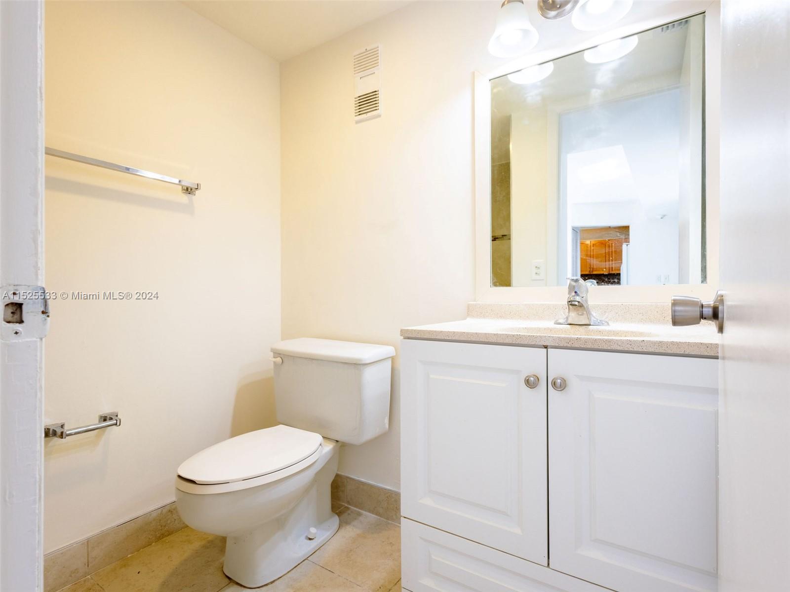 3285 Foxcroft Road, Unit E206 Miramar, FL 33025 - Photo 10 of 35 a bathroom with a toilet a sink a mirror and vanity
