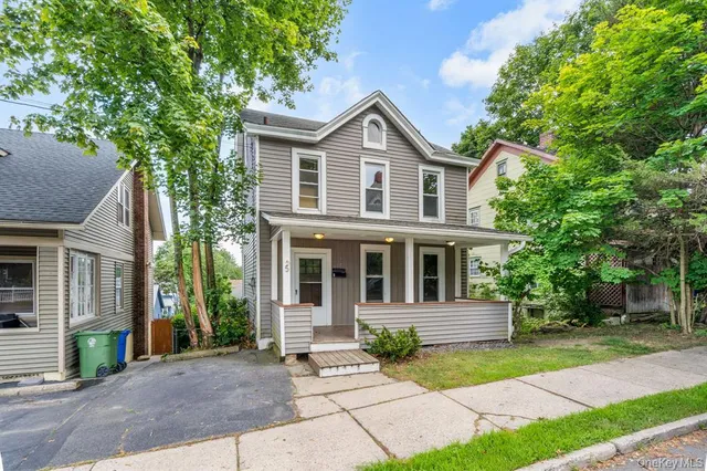 a front view of a house with a yard and trees