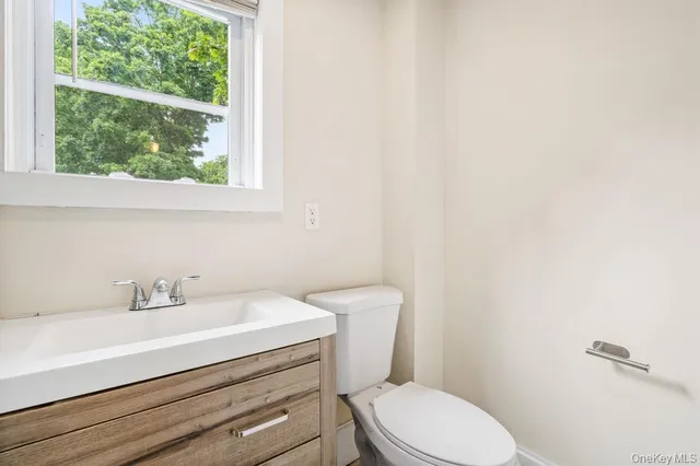 a bathroom with a sink a toilet and a window