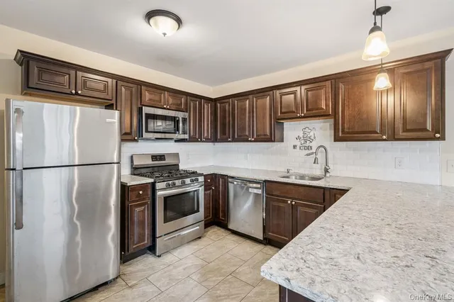 a kitchen with stainless steel appliances granite countertop a refrigerator stove top oven a sink and dishwasher