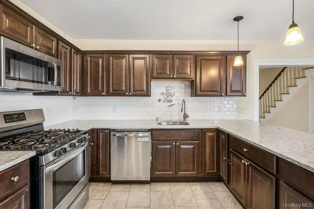 a kitchen with stainless steel appliances granite countertop a sink and stove top oven