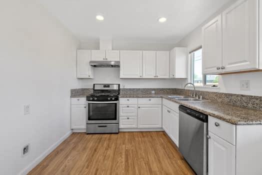 2982 D Street Selma, CA 93662 - Photo 16 of 25 a kitchen with cabinets wooden floor and stainless steel appliances
